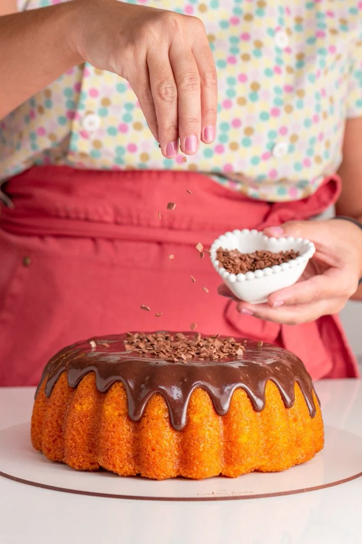 Confeiteira finalizando bolo de cenoura com brigadeiro